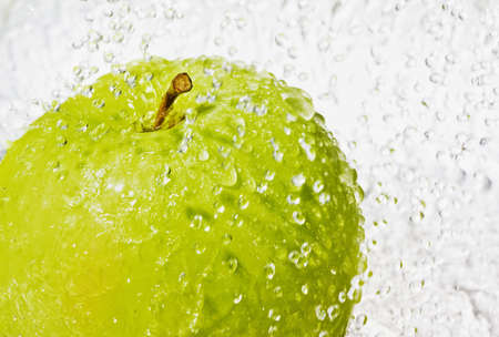 Green apple with drop of water isolated on white backgroundの写真素材