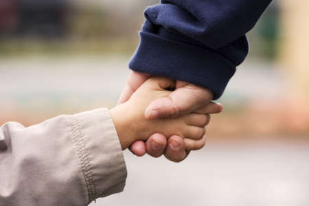 A grand-mother holding her grand-son's hand in hand