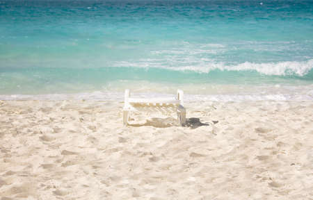 Chair isolated on a beautiful beach with sea in backの写真素材