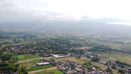 Aerial view of a village in the middle of a green fieldの写真素材