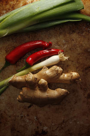 Ginger and spring onion with chili pepper on vintage metal deskの写真素材