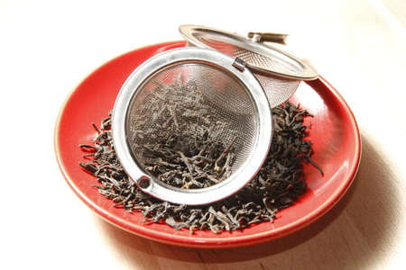 tea leaves on red plate with strainer