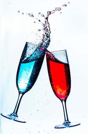 Colorful splash in champagne glass isolated on white backgroundの写真素材