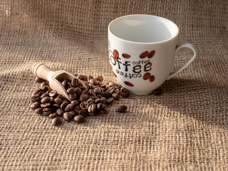 cup of coffee and beans on burlap sackの写真素材