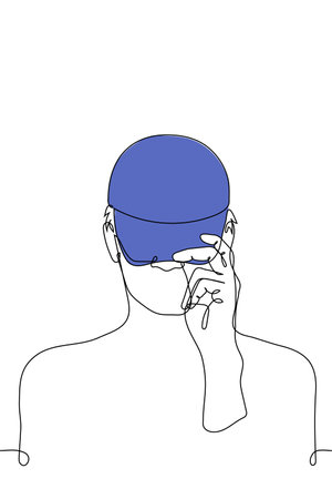 man pulling his cap over his head - one line drawing vector. the concept of trying on a baseball cap, going outside, getting ready for a project or jobのイラスト素材
