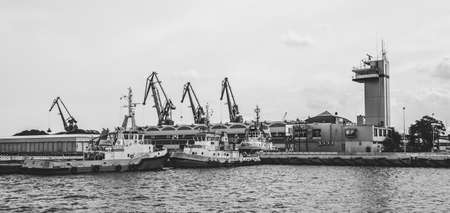 Ships in a seaport against the background of shipyard cranesの写真素材