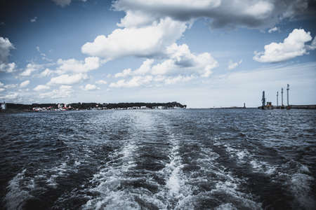 Water waves behind the ship at seaの写真素材