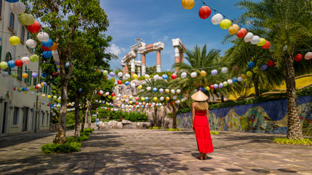 Young woman in a red dress and Vietnamese hat exploring a town on Phu Quoc Island In Vietnam.の写真素材