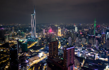 Aerial view of Kuala Lumpur city skyline at night with glowing skyscrapers and illuminated roadsの写真素材