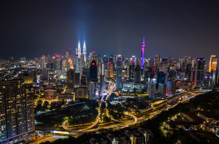 Aerial view of Kuala Lumpur city skyline at night with glowing skyscrapers and illuminated roadsの写真素材