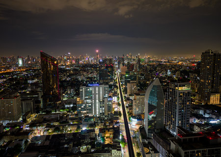 Aerial drone view of Bangkok city skyline with illuminated buildings and traffic at night, Thailandの写真素材