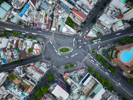 Aerial top-down view of morning traffic at intersection in residential area in Ho Chi Minh City,...