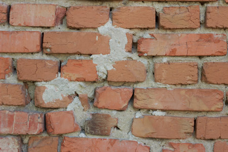 Vintage texture of an old brick wall with stains of limestone mortar