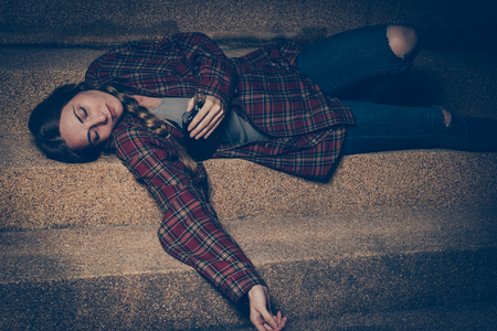 Young drunk woman sitting outside in night. Alcoholism and drug addiction lead to depression.の写真素材