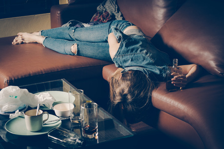 Young drunk woman on the sofa. Young drunk woman on the sofa. Alcoholism and drug addiction lead to depression.の写真素材