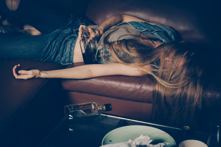 Young drunk woman on the sofa. Young drunk woman on the sofa. Alcoholism and drug addiction lead to...