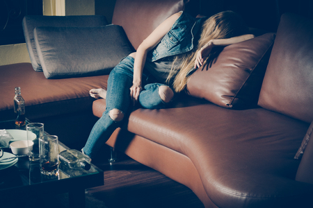 Young drunk woman on the sofa. Young drunk woman on the sofa. Alcoholism and drug addiction lead to depression.の写真素材
