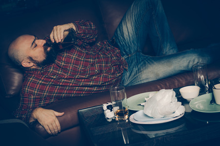 Drunk man on the sofa. concept of Alcoholism or alcohol addiction or drug addiction or depression. Unhealthy lifestyle.の写真素材