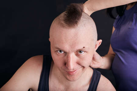 Wife doing haircut for husband at home while Covid-19 quarantine. Self isolation family lifestyle.の写真素材