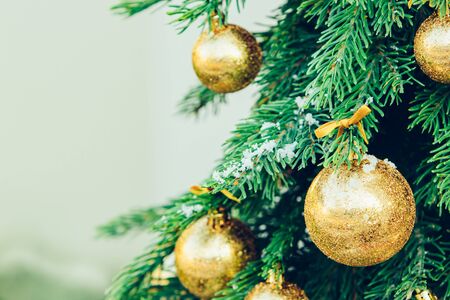 New year wallpaper. Green fir tree background with golden balls and ribbon.の写真素材