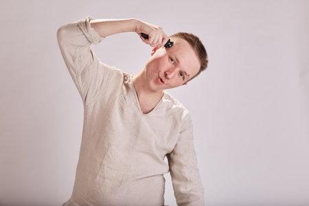 Man doing haircut by himself at home while Covid-19 quarantine. Self isolation lifestyle.の写真素材