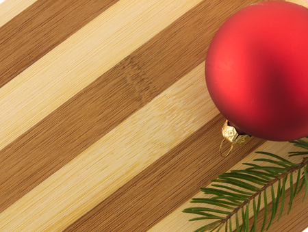 Red bauble Christmas Tree with a sprig of pine trees on a chopping board.の写真素材