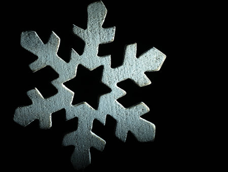 Huge white wooden snowflake and black background.の写真素材
