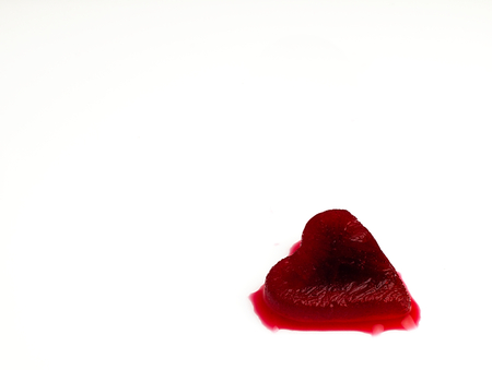 Heart of red, melting ice looking like blood on a white background.