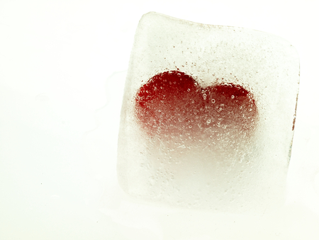 Ice cube with a heart in the middle and visible air bubbles.の写真素材