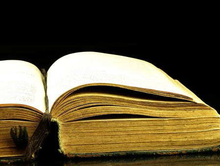 Old, open book with a damaged cover.の写真素材