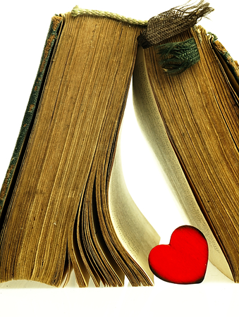 Heart and old closed the book with a damaged cover.の写真素材