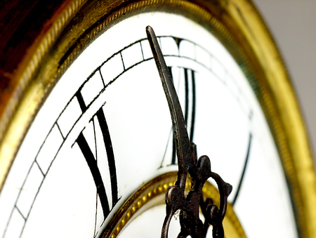 Mechanism of old clock. Clock face and hands showing five minutes to midnight.の写真素材