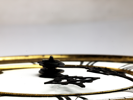 Mechanism of old clock. Clock face and hands showing five minutes to midnight.