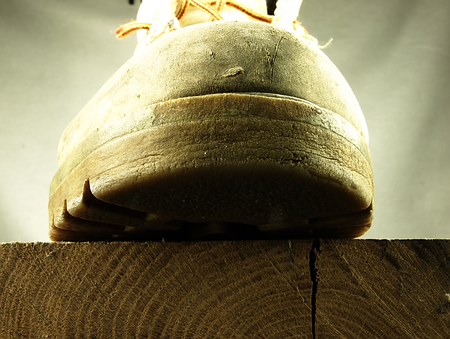 Old, heavy shoe on the edge of oak planks.の写真素材