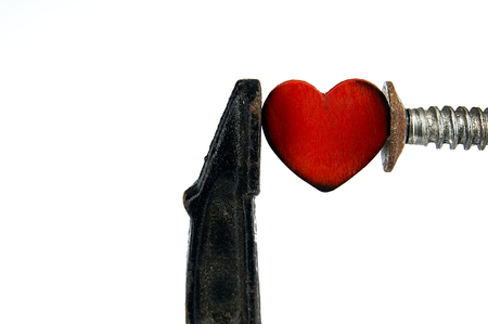 Red heart and carpenter clamp. The idea for the display of a heart attack.の写真素材