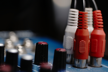 Sound console with buttons in the background and a cable in the foreground.の写真素材