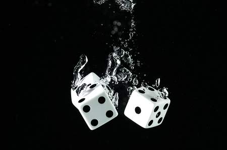 Dice playing in the water. Visible splash and air bubbles.の写真素材