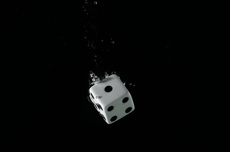 Dice playing in the water. Visible splash and air bubbles.