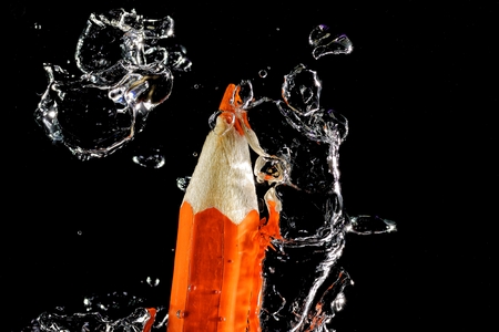 Wooden crayon under water with bubbles of air.の写真素材