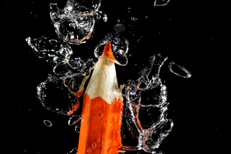 Wooden crayon under water with bubbles of air.の写真素材