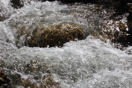 The rapids on the mountain river.Water shimmering in the sunlight.の写真素材