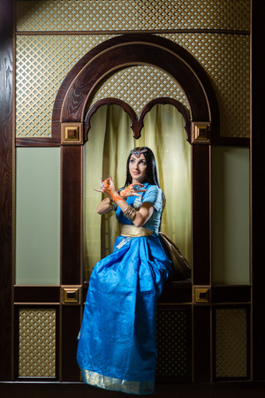 Caucasian woman in traditional Indian clothes sitting on the windowの写真素材