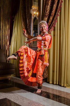 White woman is dancing in traditional indian dressの写真素材