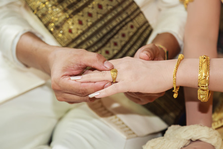Thai groom wearing wedding ring for his bride  handの写真素材