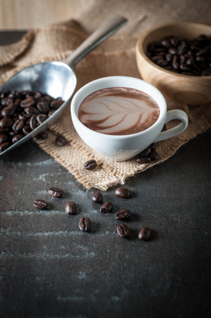 Coffee cup with coffee bean on black stone backgroundの写真素材