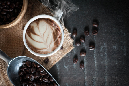 Coffee cup with coffee bean on black stone backgroundの写真素材