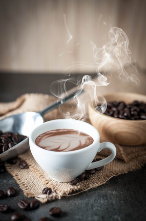 Coffee cup with coffee bean on black stone backgroundの写真素材