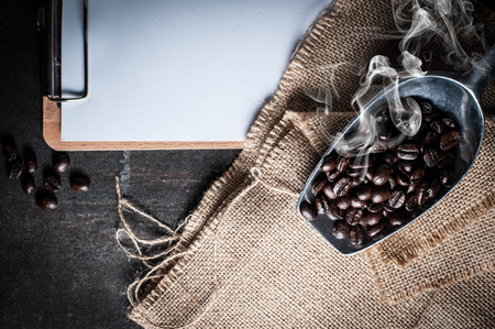 Blank clipboard with coffee bean on black stone backgroundの写真素材