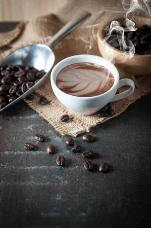 Coffee cup with coffee bean on black stone backgroundの写真素材