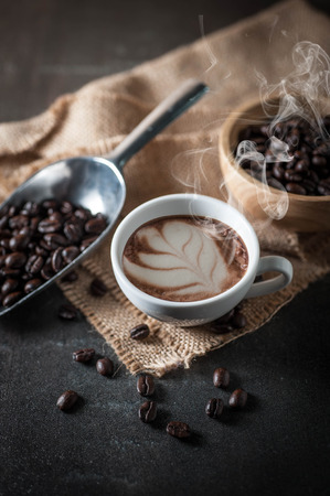 Coffee cup with coffee bean on black stone backgroundの写真素材